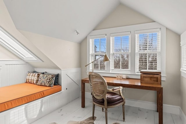 office space featuring lofted ceiling with skylight