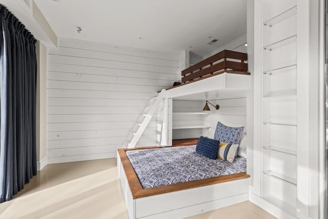 bedroom featuring wooden walls and wood-type flooring