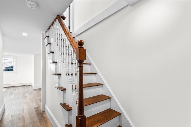 stairs with recessed lighting, wood finished floors, baseboards, and a baseboard radiator