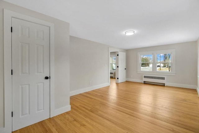 unfurnished living room with radiator and light hardwood / wood-style floors