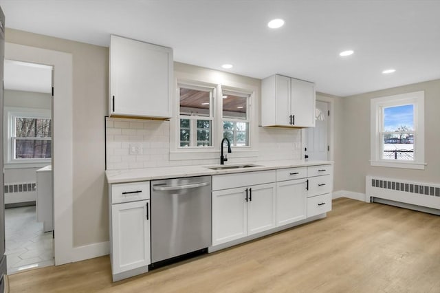 kitchen featuring sink, radiator heating unit, dishwasher, light hardwood / wood-style floors, and white cabinets