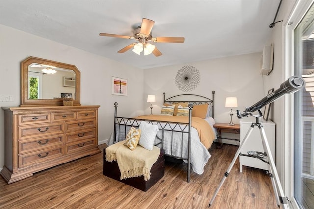 42 Sycamore Dr Unit 42, Leominster, MA 01453 - bedroom with wood finished floors, a baseboard heating unit, a wall mounted air conditioner, and a ceiling fan