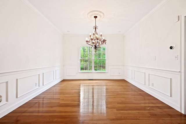 136 Howard St, Northborough, MA 01532 - unfurnished dining area with a chandelier, ornamental molding, wood finished floors, a wainscoted wall, and a decorative wall
