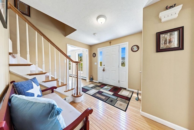 entryway with wood-type flooring, baseboards, plenty of natural light, and baseboard heating