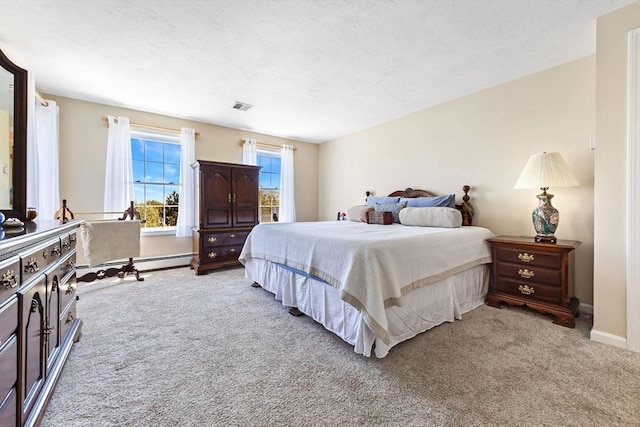 carpeted bedroom with baseboards, a baseboard radiator, and visible vents