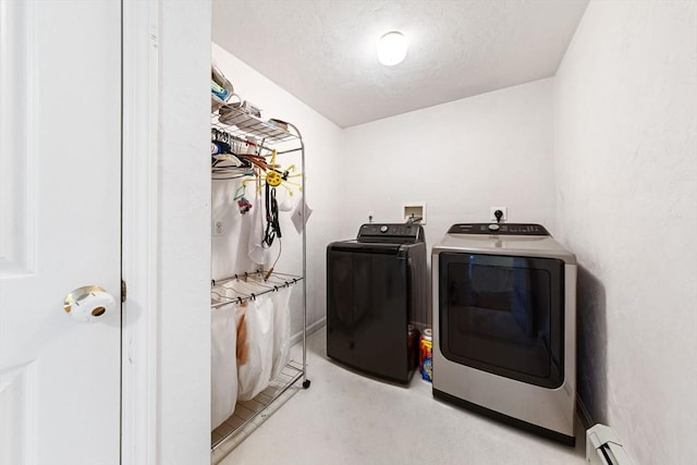 laundry area with laundry area, a baseboard heating unit, a textured ceiling, and washer and dryer