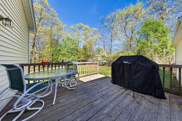 wooden deck with outdoor dining space and a grill