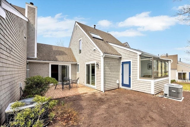 10 Lanyard Way Unit 7239, Mashpee, MA 02649 - back of house with central AC unit, a patio area, a chimney, a shingled roof, and a sunroom