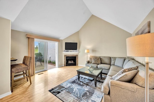 10 Lanyard Way Unit 7239, Mashpee, MA 02649 - living room featuring lofted ceiling, light wood-type flooring, a tiled fireplace, and baseboards