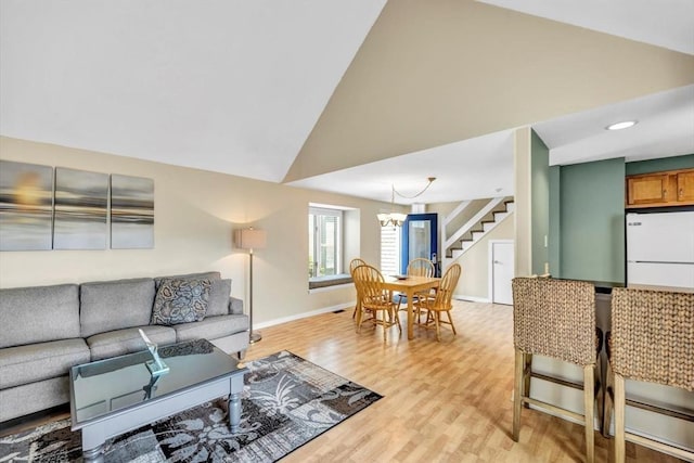 10 Lanyard Way Unit 7239, Mashpee, MA 02649 - living area with stairs, a chandelier, light wood-type flooring, baseboards, and high vaulted ceiling