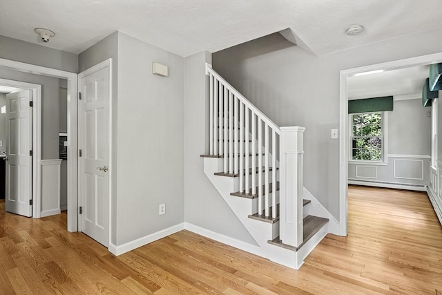 92 Clinton St, Hopkinton, MA 01748 - stairway featuring wood finished floors and a baseboard radiator