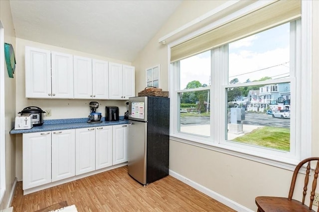 1 Shore Ave, Beverly, MA 01915 - kitchen with freestanding refrigerator, vaulted ceiling, white cabinets, light wood-type flooring, and baseboards