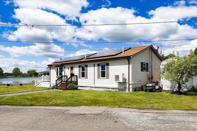 1 Shore Ave, Beverly, MA 01915 - view of front of home with solar panels, a front yard, and a water view