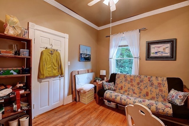 living room with ceiling fan, crown molding, and light wood-type flooring