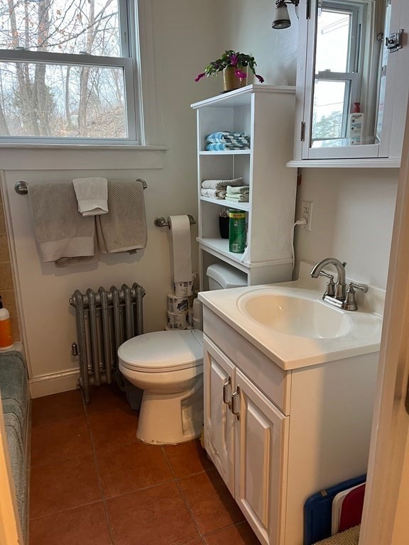 bathroom featuring radiator heating unit, tile patterned flooring, plenty of natural light, and toilet