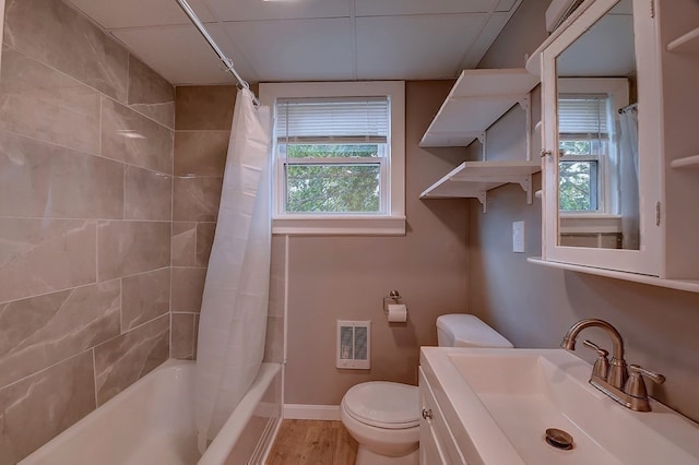 full bathroom with toilet, a wealth of natural light, heating unit, and wood-type flooring