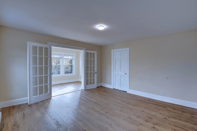 empty room with french doors and light hardwood / wood-style flooring