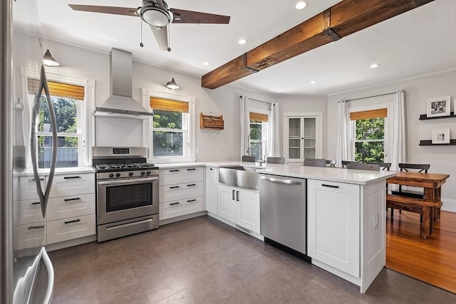 11 Draper Rd, Framingham, MA 01702 - kitchen with stainless steel appliances, wall chimney range hood, plenty of natural light, a peninsula, and recessed lighting