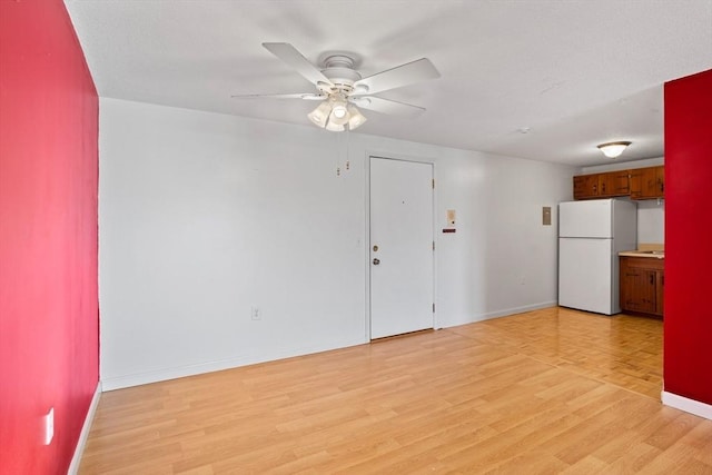 unfurnished room with ceiling fan and light wood-type flooring