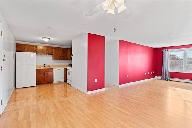 kitchen with ceiling fan, white appliances, sink, and light hardwood / wood-style flooring