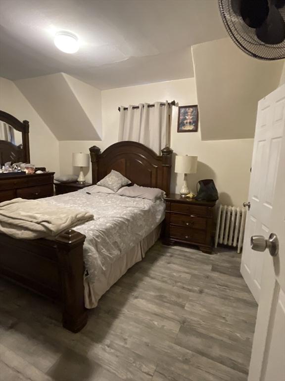 9 Cedar St, Lynn, MA 01905 - bedroom with radiator heating unit, wood finished floors, and vaulted ceiling