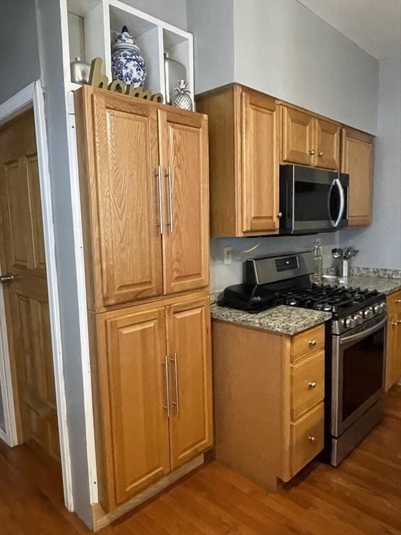 9 Cedar St, Lynn, MA 01905 - kitchen featuring appliances with stainless steel finishes, wood finished floors, light stone countertops, and brown cabinetry