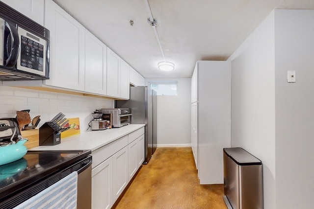 kitchen featuring white cabinets, appliances with stainless steel finishes, and decorative backsplash