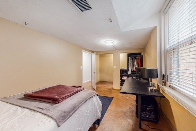 carpeted bedroom featuring a textured ceiling and a closet