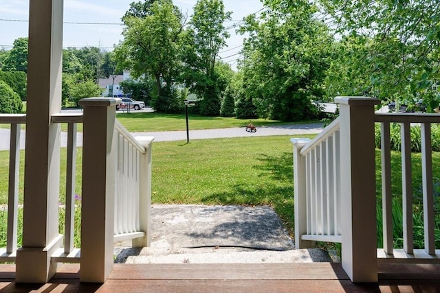 view of gate featuring a porch and a lawn