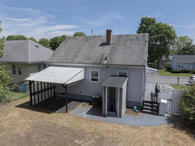 33 Altoona Rd, Dedham, MA 02026 - back of property featuring central AC, a chimney, and a gate