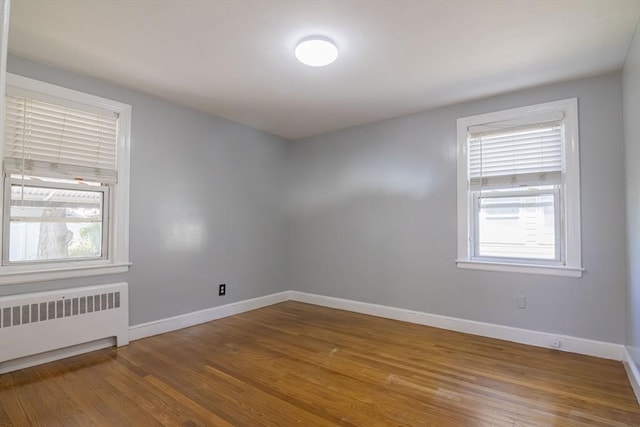 33 Altoona Rd, Dedham, MA 02026 - unfurnished room with radiator heating unit, plenty of natural light, wood finished floors, and baseboards