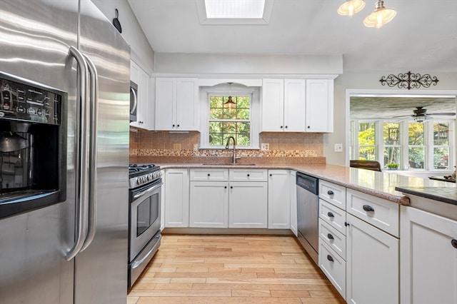 kitchen featuring light hardwood / wood-style floors, appliances with stainless steel finishes, sink, and tasteful backsplash