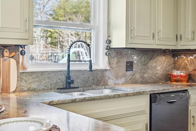 kitchen featuring tile counters, backsplash, black dishwasher, and a sink