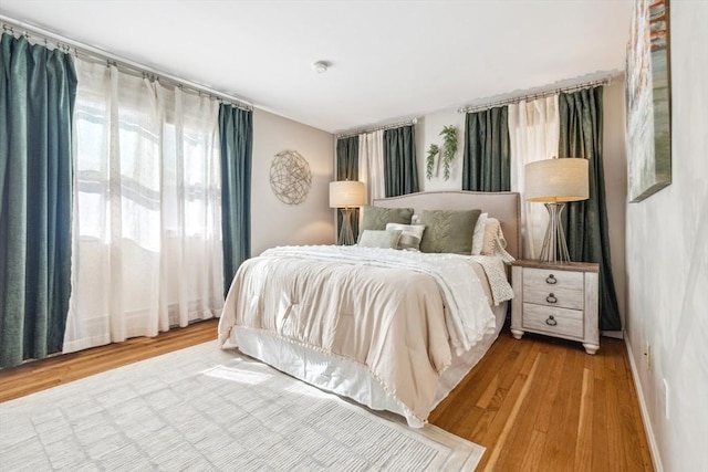 bedroom with baseboards and wood finished floors