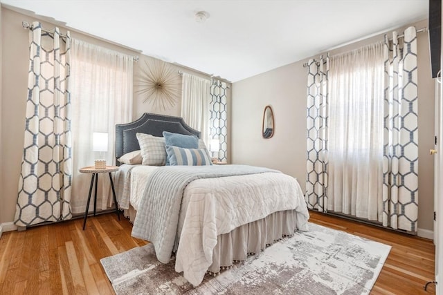 bedroom with baseboards and wood finished floors