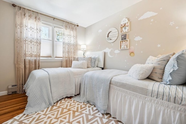 bedroom featuring a baseboard radiator and wood finished floors