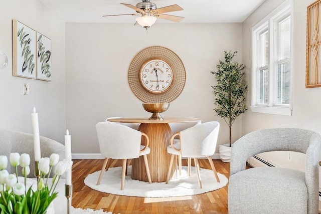 dining area with baseboards, a ceiling fan, and wood finished floors