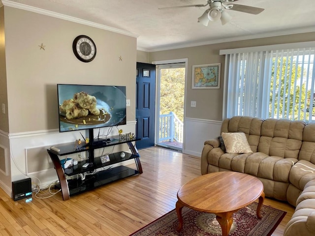 living room with ceiling fan, ornamental molding, hardwood / wood-style floors, and wainscoting