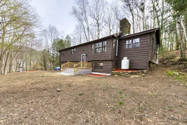 back of house featuring a chimney