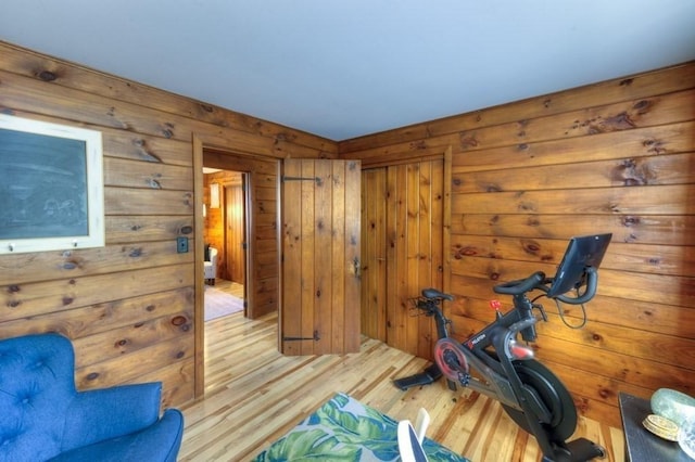workout area with wooden walls and wood finished floors