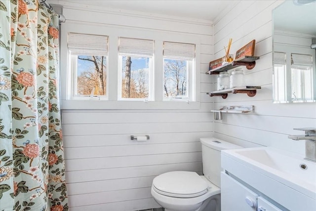 bathroom featuring wood walls, vanity, a shower with shower curtain, and toilet