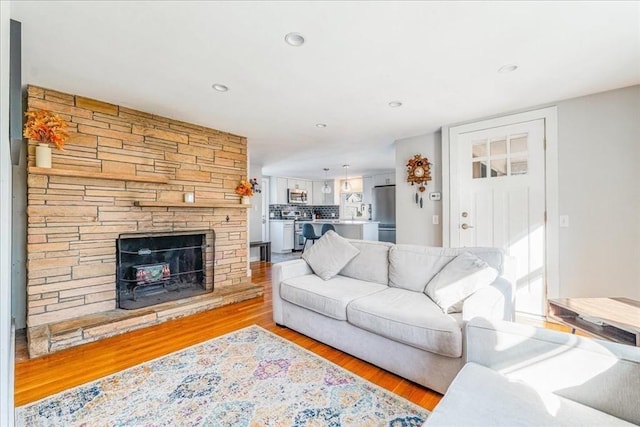 living room with a fireplace and light wood-type flooring