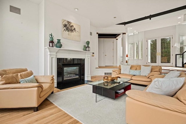44 Southpoint Ln, Ipswich, MA 01938 - living area with light wood finished floors, a fireplace with flush hearth, recessed lighting, and french doors