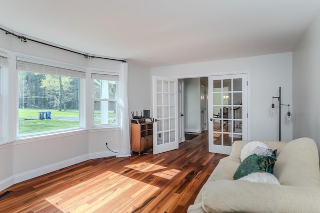 living room with baseboards, french doors, and wood finished floors