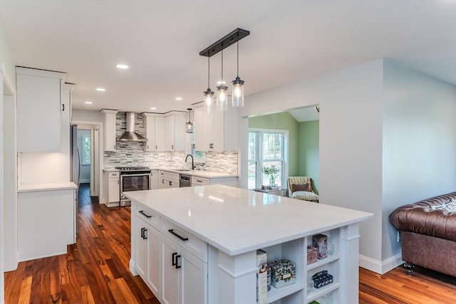 kitchen featuring open shelves, dark wood-style flooring, wall chimney exhaust hood, a sink, and appliances with stainless steel finishes