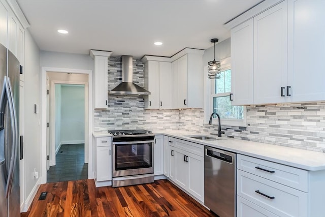 kitchen with light countertops, a sink, wall chimney exhaust hood, and stainless steel appliances