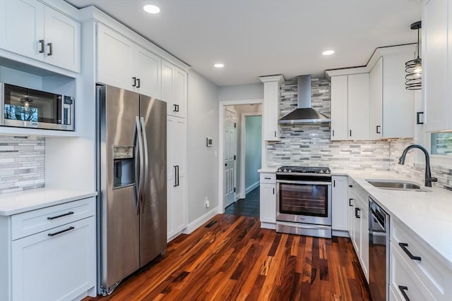 kitchen featuring a sink, light countertops, wall chimney exhaust hood, stainless steel appliances, and backsplash
