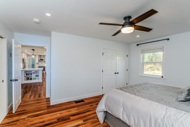 bedroom with a closet, recessed lighting, and wood finished floors