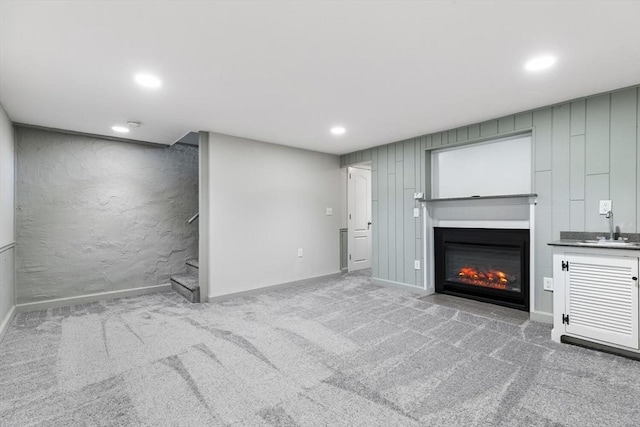 unfurnished living room with carpet floors and sink