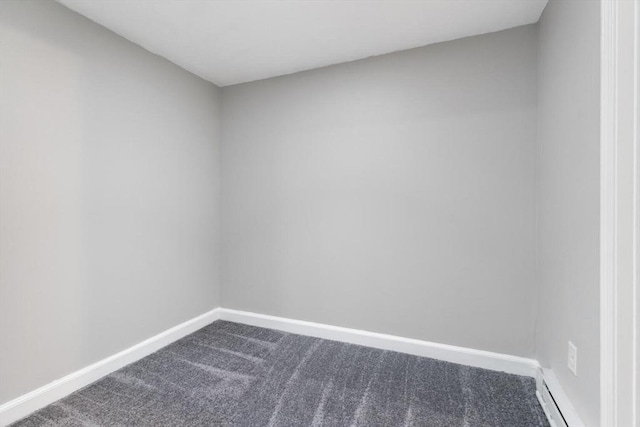 spare room featuring baseboard heating and carpet